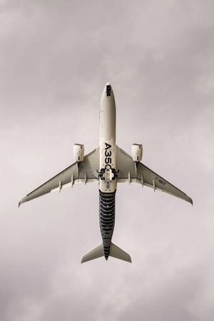 Jet Iphone Soaring Against Grey Sky Wallpaper