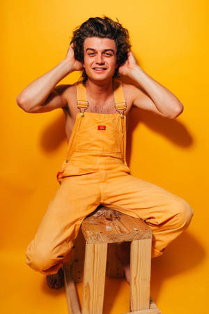 Joe Keery In Yellow Jumper Wallpaper