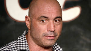 Joe Rogan Smiling At Viewer Wallpaper