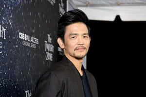 John Cho Striking A Stylish Pose In A Photoshoot Wallpaper
