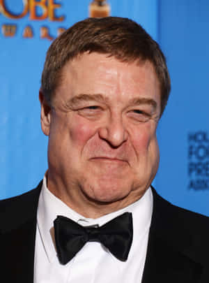 John Goodman Smiling In A Formal Outfit Wallpaper