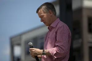John Hickenlooper Addressing Audience With Microphone Wallpaper