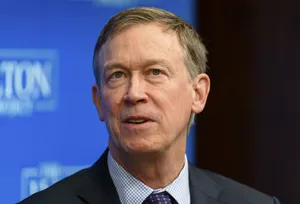 John Hickenlooper Against A Blue And Black Backdrop Wallpaper