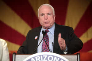 John Mc Cain Speakingat Podium Wallpaper