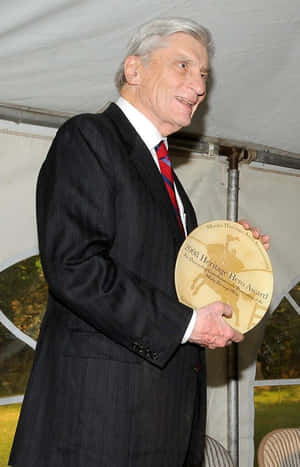 John Warner Holding A Trophy Phone Wallpaper