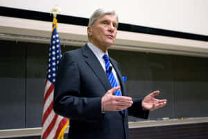 John Warner Speaking In Front Of American Flag Wallpaper