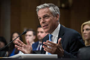 Jon Huntsman Engaging With Hand Gesture Wallpaper