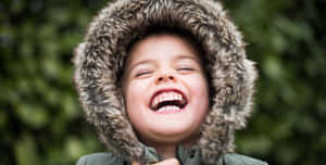 Joyful Child Laughing Outdoors.jpg Wallpaper