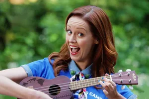 Joyful Ukulele Player Outdoors Wallpaper