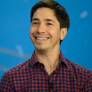 Justin Long Smiling At A Photo Shoot Wallpaper