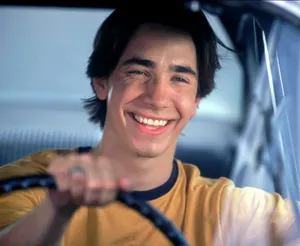 Justin Long Striking A Casual Pose On An Urban Streetscape Wallpaper
