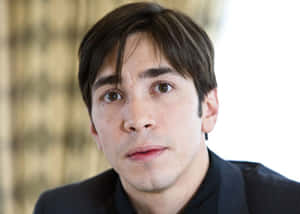 Justin Long Striking A Confident Pose In Style Wallpaper