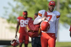 Kansas City Chiefs Player Carrying Helmetand Gear Wallpaper