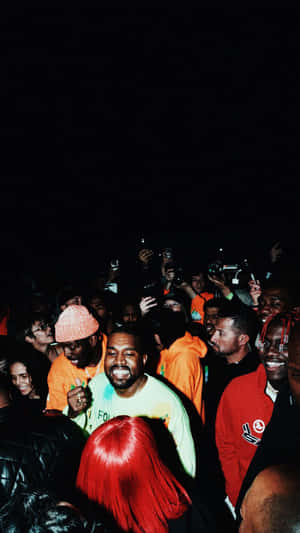 Kanye West Surroundedby Fans Night Event Wallpaper