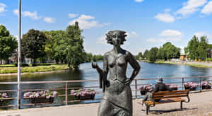 Karlstad Riverside Sculptureand Bench Scene Wallpaper