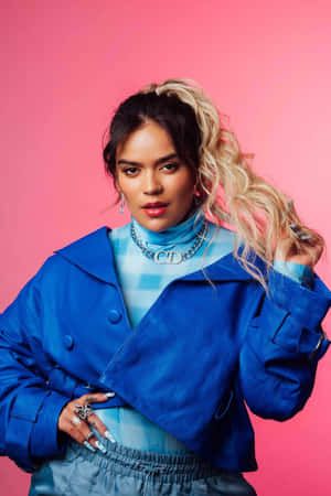 Karol G Blue Jacket Pink Backdrop Wallpaper