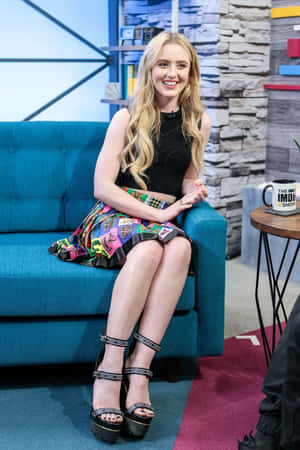 Kathryn Newton Sitting On Blue Couch Wallpaper