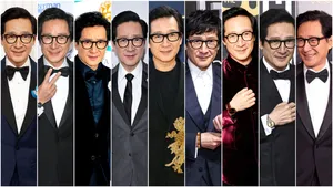 Ke Huy Quan Striking A Pose In A Stylish Suit Wallpaper