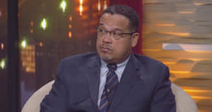 Keith Ellison Sitting During Live Interview Wallpaper