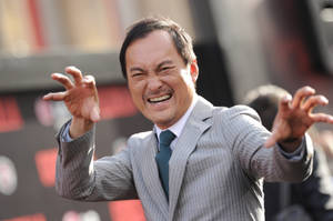 Ken Watanabe Exhibiting A Funny Pose On The Red Carpet Wallpaper