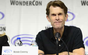 Kevin Conroy With A Microphone In A Sound Booth Wallpaper