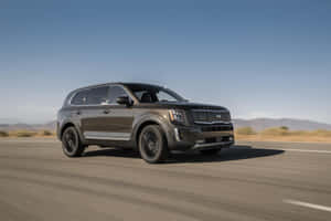 Kia Telluride Driving Through Rugged Terrain Wallpaper