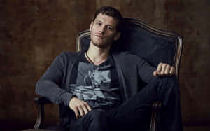 Klaus Mikaelson Posing On A Chair Wallpaper
