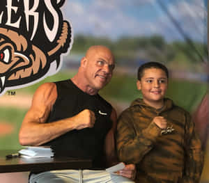 Kurt Angle Enjoying A Cheerful Moment With A Fan Wallpaper