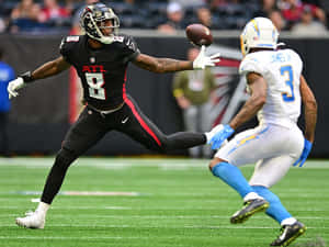 Kyle Pitts Reaching For Football During Game Wallpaper