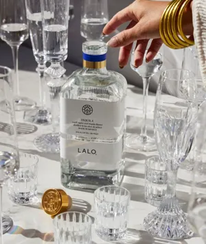 Lalo Tequila Bottle Among Crystal Glasses Wallpaper