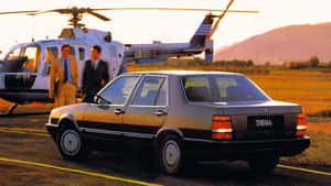 Lancia Thema With Helicopter Backdrop Wallpaper