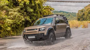 Land Rover Defender Driving On A Mountain Terrain Wallpaper