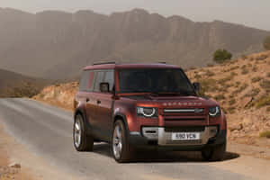 Land Rover Defender Traversing A Rugged Terrain Wallpaper
