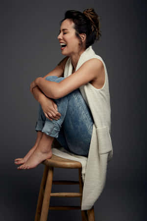 Laughing Woman Sittingon Stool Wallpaper