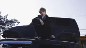 Lee Know Sittingon Car Hood Wallpaper