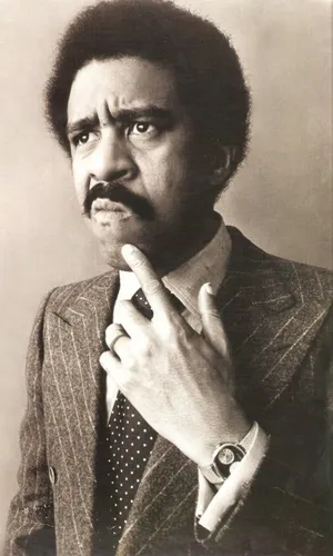 Legendary Comedian Richard Pryor Holding A Mic On Stage Wallpaper