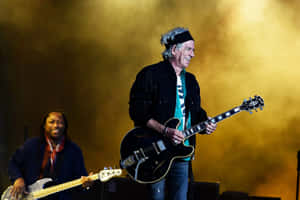 Legendary Guitarist On Stage With Bassist Wallpaper