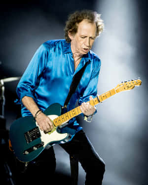 Legendary Guitaristin Blue Shirt Performing Wallpaper