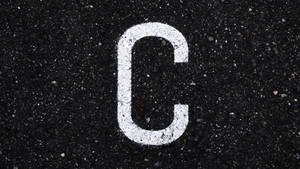 Letter C On Black Asphalt Wallpaper