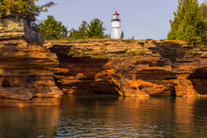 Lighthouse Over Red Rock Formations Wallpaper