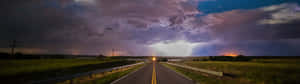 Lightning Over A Road With A Cloudy Sky Wallpaper