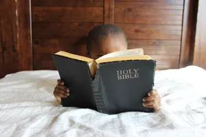 Little Girl Reading The Holy Bible Wallpaper