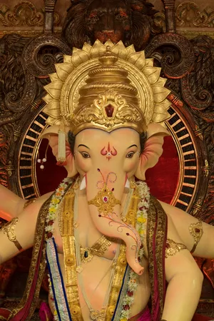 Lord Ganesha Statue Adornedin Golden Ornaments Wallpaper