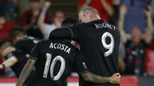 Luciano Acosta And Team Captain Rooney Wallpaper