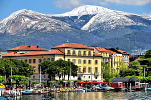 Lugano Lakefrontwith Snow Capped Mountain Backdrop Wallpaper