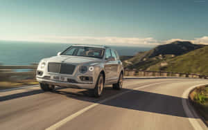 Luxurious Bentley Bentayga Suv Cruising On The Open Road Wallpaper