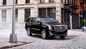 Luxurious Cadillac Escalade Cruising On A Scenic Path Wallpaper