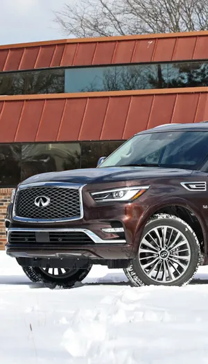 Luxurious Infiniti Qx80 Cruising In The City Wallpaper