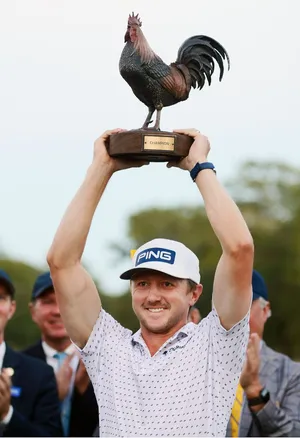 Mackenzie Hughes Holding Trophy Up Wallpaper