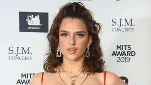 Mae Muller Poses Confidently During A Photoshoot. Wallpaper